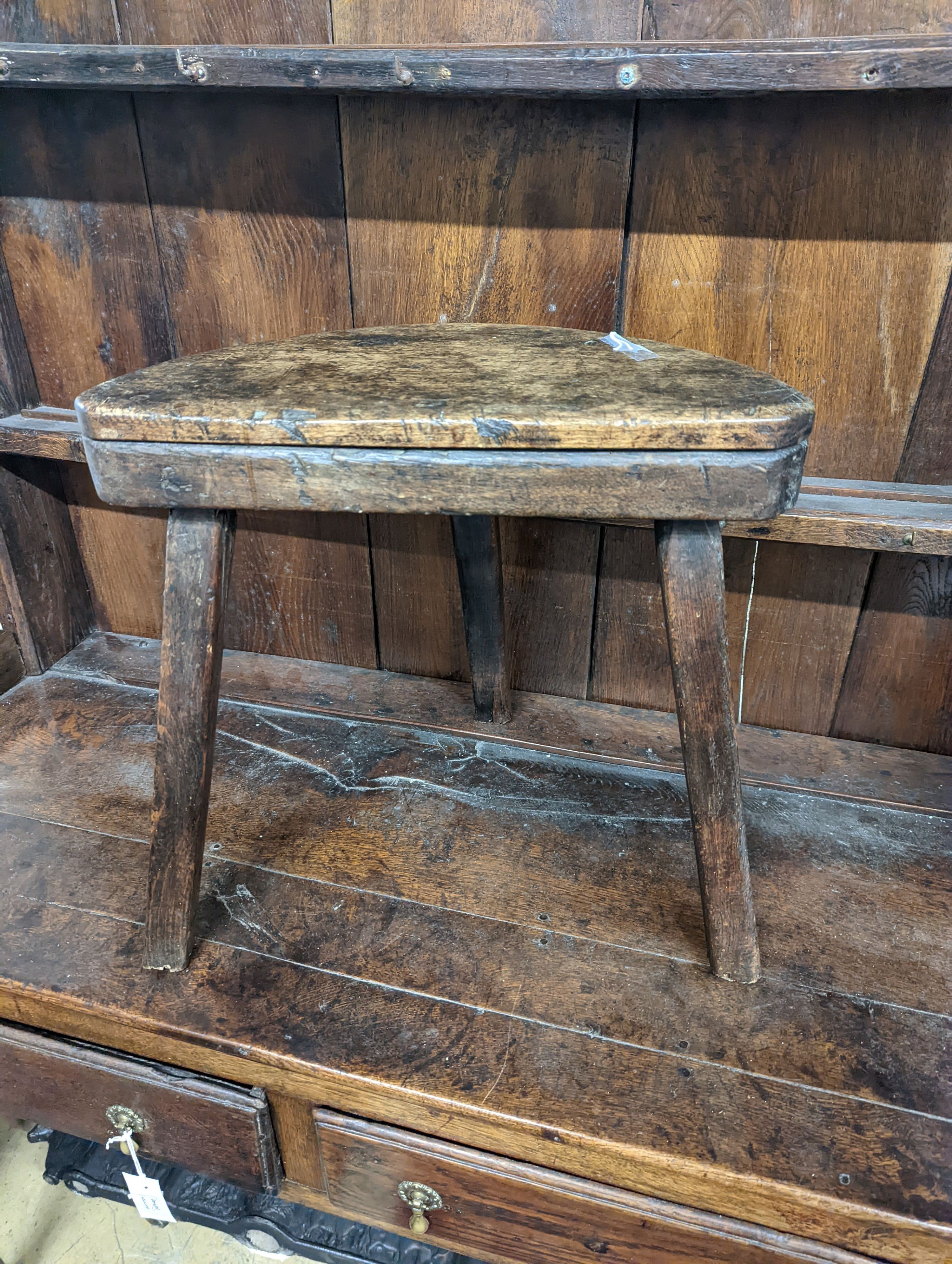 A 19th century primitive fruitwood stool. W-47cm, D-22cm, H-45cm.